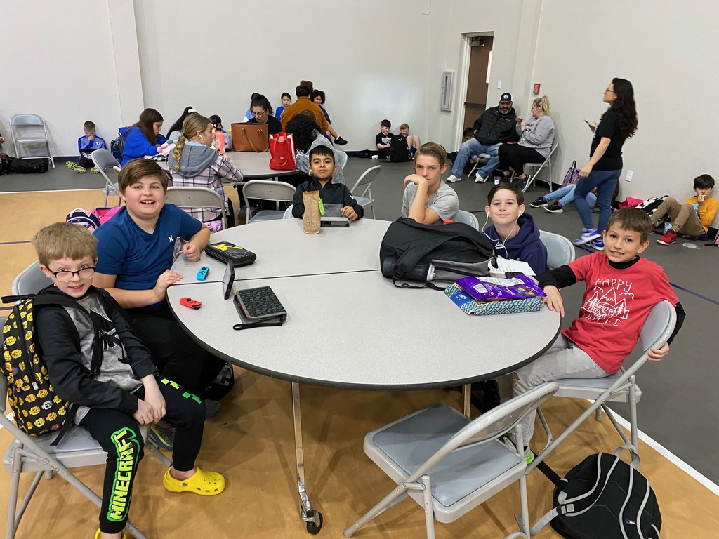 Boys seated around a table visiting. 