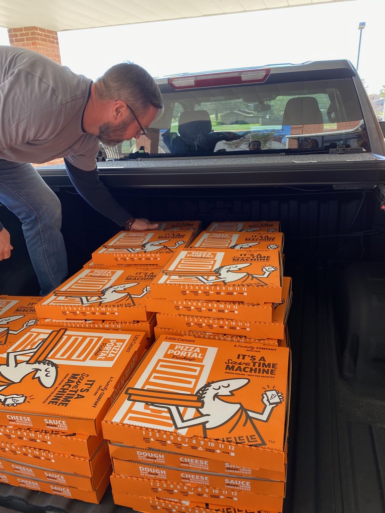 The back of a truck filled with 52 pizzas. 