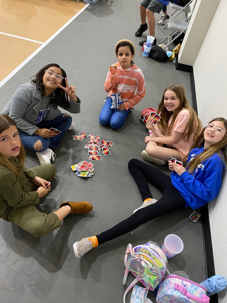 Students sitting on floor playing uno.